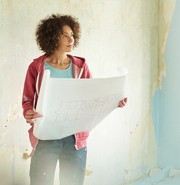 woman looking at building plans for buy to let property